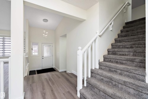 Entryway with light-toned flooring, a white door with decorative glass, and an overhead light fixture - 11020 158 Avenue, Edmonton, AB - Indoor Photo Showing Other Room