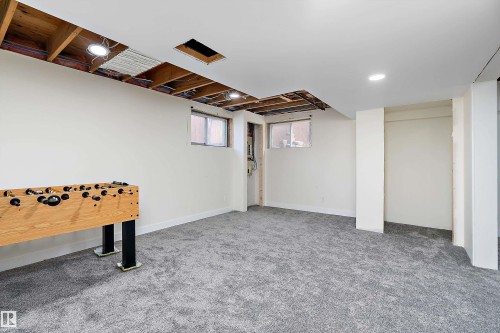 The property features a spacious room with light gray carpet and white walls - 11020 158 Avenue, Edmonton, AB - Indoor Photo Showing Basement