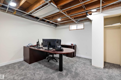 This space features grey carpet flooring and white walls, with a window and an open closet - 11020 158 Avenue, Edmonton, AB - Indoor Photo Showing Office