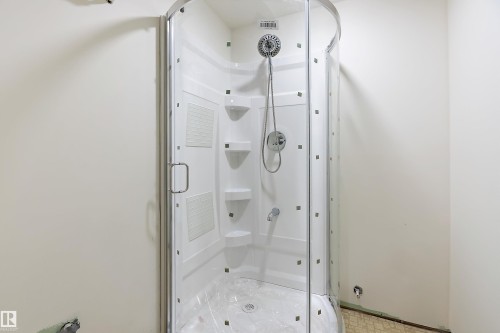 The property features a white corner shower enclosure with clear glass doors and a chrome shower head with an attached hose - 11020 158 Avenue, Edmonton, AB - Indoor Photo Showing Bathroom