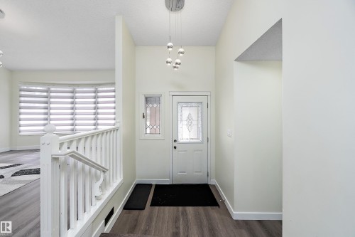 Inviting entryway featuring dark wood flooring, a white front door with decorative glass, and an overhead light fixture - 11020 158 Avenue, Edmonton, AB - Indoor Photo Showing Other Room