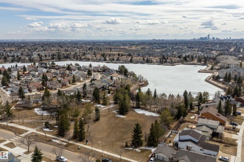 This aerial view showcases the property's proximity to a lake, surrounded by a residential area with varied housing styles - 11020 158 Avenue, Edmonton, AB - Outdoor With View