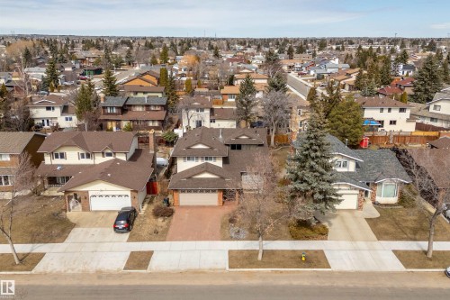The property features a spacious two-story design with an attached garage, a paved driveway, and mature landscaping - 11020 158 Avenue, Edmonton, AB - Outdoor With View