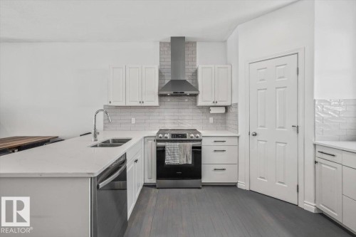 The kitchen features white cabinetry, stainless steel appliances, and a subway tile backsplash - 8737 83 Avenue, Edmonton, AB - Indoor Photo Showing Kitchen With Double Sink With Upgraded Kitchen