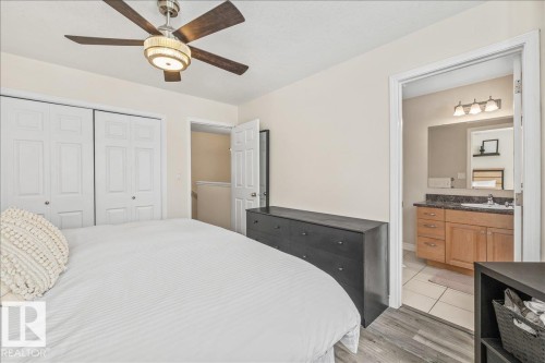 This room features a ceiling fan, light wood style flooring, and white bifold closet doors - 8737 83 Avenue, Edmonton, AB - Indoor Photo Showing Bedroom