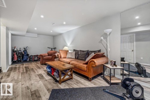This versatile room features light-colored walls and recessed lighting throughout, complemented by wood-look flooring - 8737 83 Avenue, Edmonton, AB - Indoor Photo Showing Other Room