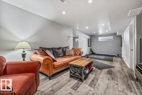 Versatile area featuring light-colored walls, recessed lighting, and wood-style flooring - 8737 83 Avenue, Edmonton, AB - Indoor