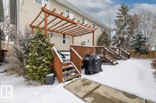 The property features a wooden deck with a pergola, accessible via wooden stairs - 8737 83 Avenue, Edmonton, AB - Outdoor With Exterior
