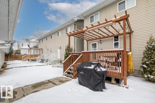 The property features a wooden deck with a pergola, string lighting, and direct access to the interior - 8737 83 Avenue, Edmonton, AB - Outdoor With Deck Patio Veranda With Exterior