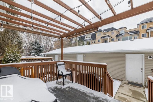 The property features a wooden deck with a slatted pergola, adorned with string lights - 8737 83 Avenue, Edmonton, AB - Outdoor With Deck Patio Veranda With Exterior
