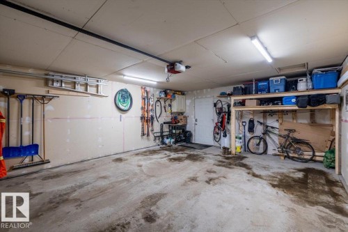 Spacious garage featuring concrete flooring and ample overhead lighting - 8737 83 Avenue, Edmonton, AB - Indoor Photo Showing Garage