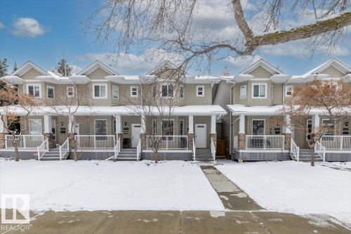 The property features a multi-unit facade with gabled roofs, light-colored siding, and white trim - 8737 83 Avenue, Edmonton, AB - Outdoor With Deck Patio Veranda With Facade