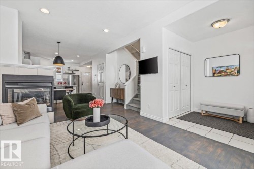 Open concept living area with a fireplace, recessed lighting, and dark hardwood flooring - 8737 83 Avenue, Edmonton, AB - Indoor Photo Showing Living Room With Fireplace