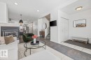 Open concept living area with a fireplace, recessed lighting, and dark hardwood flooring - 8737 83 Avenue, Edmonton, AB  - Indoor Photo Showing Living Room With Fireplace 