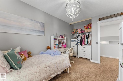Bedroom featuring light gray walls, carpeted flooring, and a built-in closet with storage - 3908 44 Avenue, Stony Plain, AB - Indoor Photo Showing Bedroom