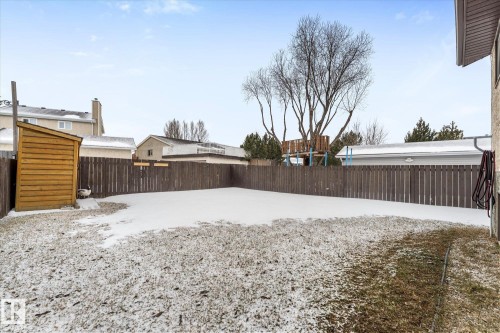 The property features a fenced backyard with a wooden storage shed - 3908 44 Avenue, Stony Plain, AB - Outdoor