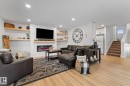 Living area featuring light wood flooring, an accent wall with shiplap detailing, an electric fireplace, and recessed lighting - 3908 44 Avenue, Stony Plain, AB  - Indoor Photo Showing Other Room With Fireplace 
