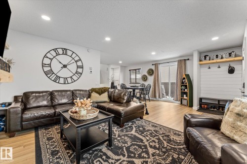 The spacious living area features recessed lighting, hardwood style flooring, and a large decorative wall clock - 3908 44 Avenue, Stony Plain, AB - Indoor Photo Showing Living Room