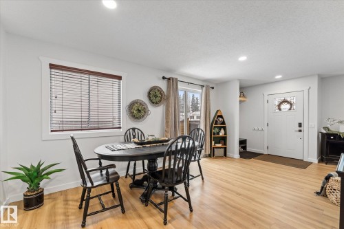Well-lit dining area featuring light-colored hardwood flooring, a large window with blinds, and recessed lighting - 3908 44 Avenue, Stony Plain, AB - Indoor Photo Showing Dining Room