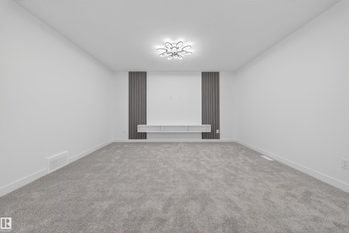 Spacious room featuring light gray carpet flooring, white painted walls, and white baseboards - 3906 41 Avenue, Beaumont, AB - Indoor Photo Showing Other Room
