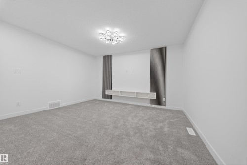 Spacious room featuring light gray carpeting, crisp white walls, and a contemporary ceiling light fixture - 3906 41 Avenue, Beaumont, AB - Indoor Photo Showing Other Room
