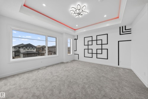 Expansive room featuring a tray ceiling with integrated red accent lighting and recessed lighting - 3906 41 Avenue, Beaumont, AB - Indoor Photo Showing Other Room