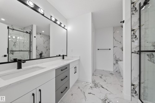 Modern bathroom featuring a dual vanity with rectangular undermount sinks, white countertops, and matte black faucets - 3906 41 Avenue, Beaumont, AB - Indoor Photo Showing Bathroom