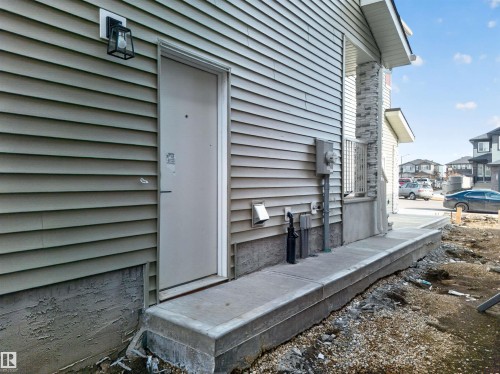 Siding exterior with a concrete entryway and stone-clad pillar - 3906 41 Avenue, Beaumont, AB - Outdoor