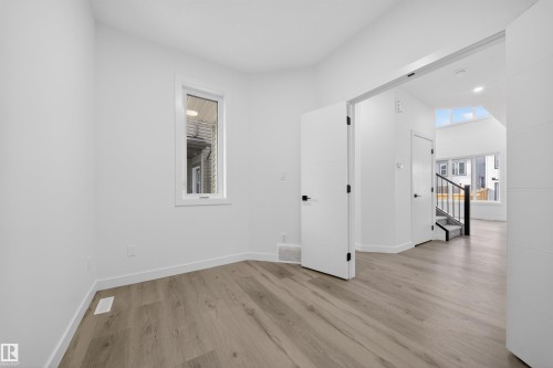 Bright interior space featuring light wood-finish flooring and white walls - 3906 41 Avenue, Beaumont, AB - Indoor Photo Showing Other Room