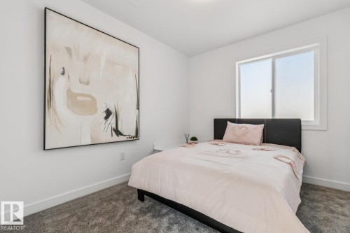 Bright interior space featuring a window with white trim, plush gray carpeting, and white baseboards - 10726 107 Street, Edmonton, AB - Indoor Photo Showing Bedroom