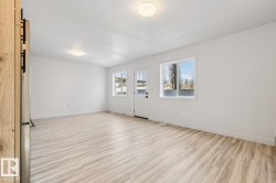 Open room featuring light wood-finish flooring, white walls, and recessed lighting fixtures - 