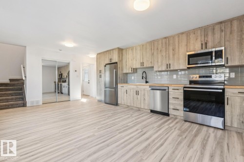Full kitchen featuring stainless steel appliances, light wood-finish cabinetry, a subway tile backsplash, and wood-finish countertops - 10726 107 Street, Edmonton, AB - Indoor Photo Showing Kitchen With Stainless Steel Kitchen