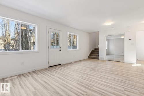 Bright living space featuring light wood-finish flooring, white walls, and multiple windows - 10726 107 Street, Edmonton, AB - Indoor Photo Showing Other Room