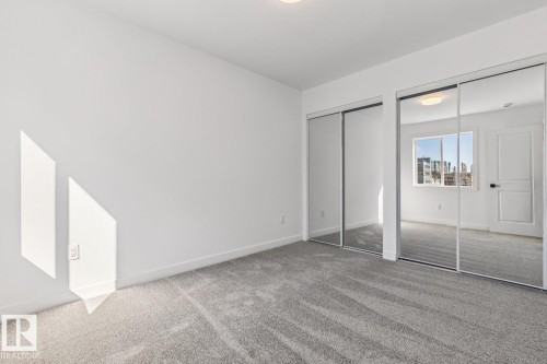 Room featuring light gray carpeting, crisp white walls, and dual mirrored closet doors - 10726 107 Street, Edmonton, AB - Indoor Photo Showing Other Room