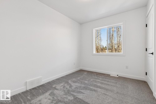 Room featuring gray textured carpeting, white baseboards, and a white framed window - 10726 107 Street, Edmonton, AB - Indoor Photo Showing Other Room