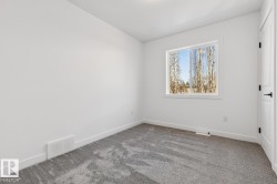 Room featuring gray textured carpeting, white baseboards, and a white framed window - 