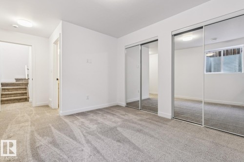 Carpeted room with white walls, two sets of mirrored sliding closet doors, and recessed lighting - 10726 107 Street, Edmonton, AB - Indoor Photo Showing Other Room