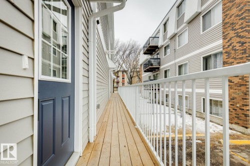 Exterior balcony featuring light wood-finish decking and a white metal railing - 10726 107 Street, Edmonton, AB - Outdoor With Exterior