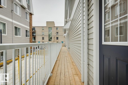 Exterior wood-finish balcony with white metal railings - 10726 107 Street, Edmonton, AB - Outdoor With Exterior
