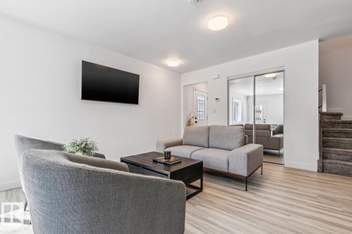 Bright interior space featuring light wood-finish flooring, recessed lighting, and a wall-mounted flat-screen television - 10726 107 Street, Edmonton, AB - Indoor Photo Showing Living Room
