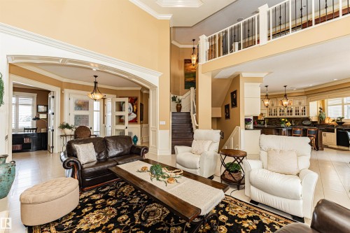 Spacious living area featuring high ceilings, an elegant staircase, and an open concept layout into the kitchen - 3048 Watson Landing, Edmonton, AB - Indoor Photo Showing Living Room