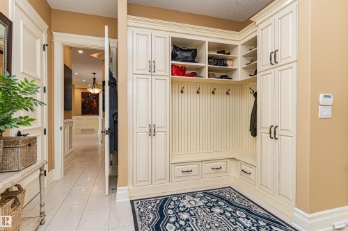 Entryway featuring custom built-in cabinetry with storage cubbies and coat hooks, a built-in bench with drawers, and tile flooring - 3048 Watson Landing, Edmonton, AB - Indoor Photo Showing Other Room