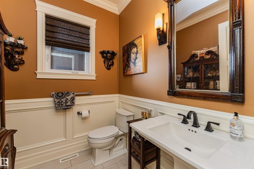 The bathroom features a vanity with a white countertop and a white sink with a dark-toned faucet - 3048 Watson Landing, Edmonton, AB - Indoor Photo Showing Bathroom
