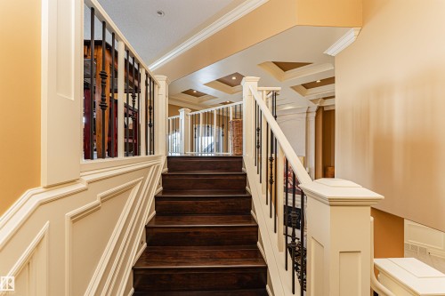 The elegant staircase features dark wood treads, white risers, and a white railing with black metal balusters - 3048 Watson Landing, Edmonton, AB - Indoor Photo Showing Other Room
