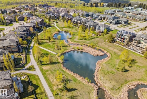 Aerial perspective showcasing the property, walkout basement, and that the home backs onto Hyman Pond. - 3048 Watson Landing, Edmonton, AB - Outdoor With Body Of Water With View