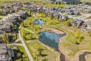 Aerial perspective showcasing the property, walkout basement, and that the home backs onto Hyman Pond. - 3048 Watson Landing, Edmonton, AB  - Outdoor With Body Of Water With View 