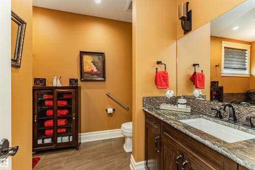 Bathroom featuring a dark wood vanity with a granite countertop, a white rectangular sink, and a large mirror - 3048 Watson Landing, Edmonton, AB - Indoor Photo Showing Bathroom
