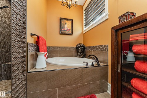 The bathroom features a built-in tub with dark bronze fixtures and a decorative tiled surround - 3048 Watson Landing, Edmonton, AB - Indoor Photo Showing Bathroom