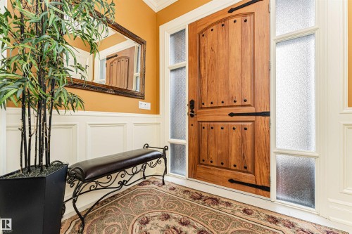 Entryway featuring a decorative wooden door with dark hardware, frosted side windows, and wainscoting - 3048 Watson Landing, Edmonton, AB - Indoor Photo Showing Other Room