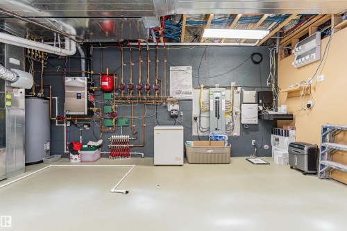 Utility space featuring a water heater, an extensive piping system, and an exposed ceiling with ductwork - 3048 Watson Landing, Edmonton, AB - Indoor Photo Showing Basement